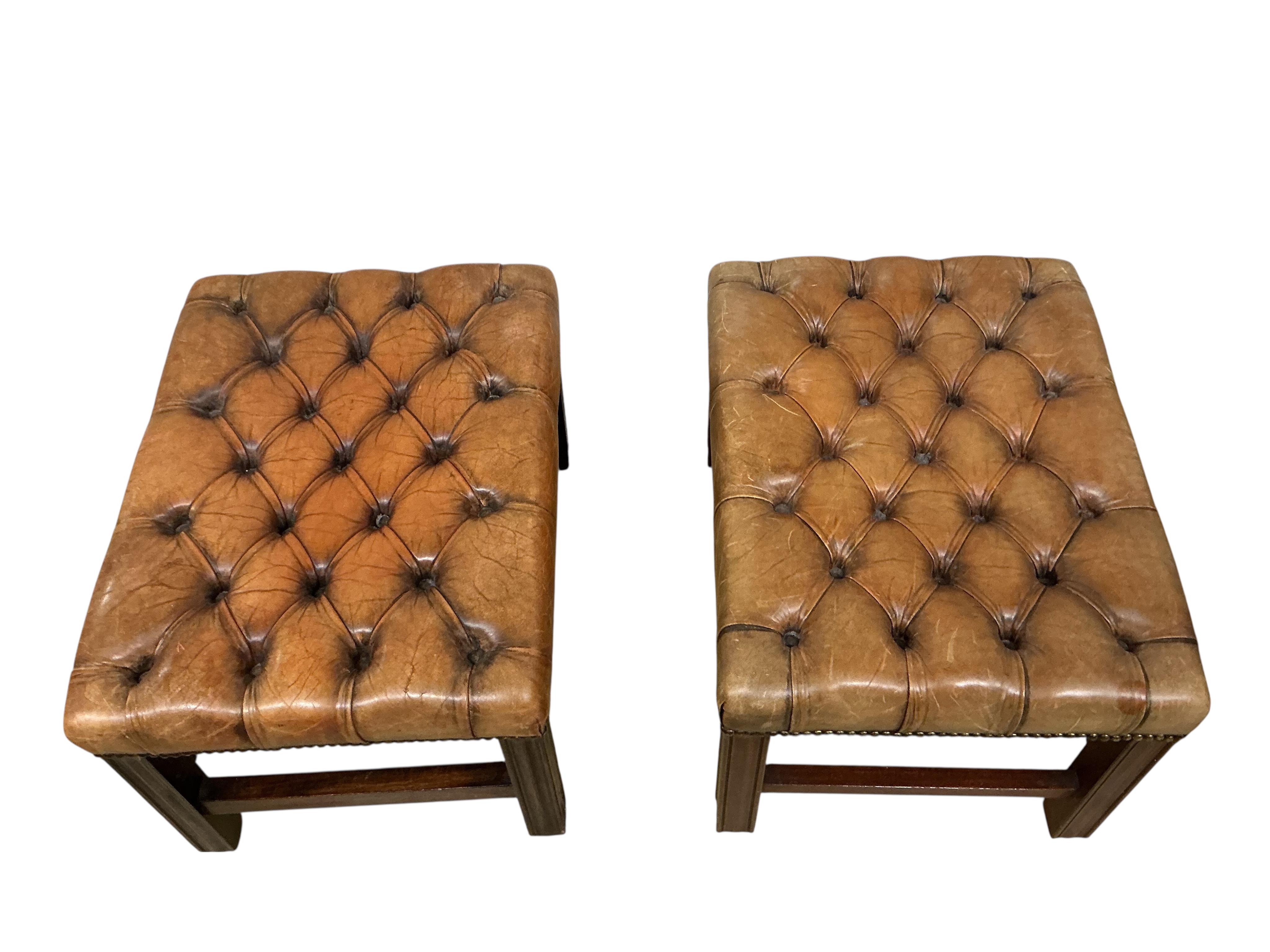 A pair of George III style buttoned brown leather rectangular mahogany stools, width 58cm, depth 44cm, height 36cm